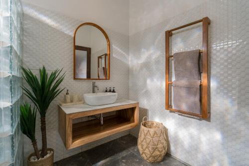 a bathroom with a sink and a mirror at Villa Skyler Seminyak in Seminyak