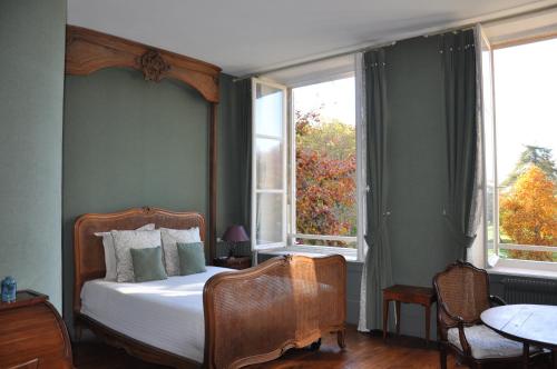 a bedroom with a bed and two windows at Le Pavillon Saint Martin in Senlis