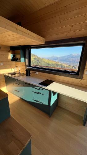 a kitchen with a large window in a cabin at Flow Hill in Kościelisko