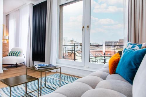 a living room with a couch and a large window at City Sky Lodge in Budapest