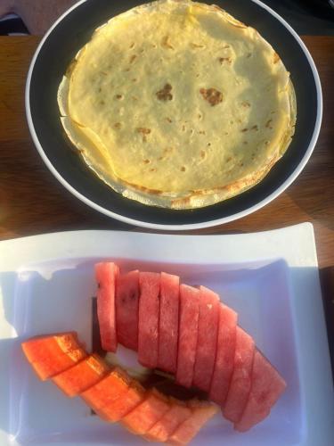 a plate of watermelon and a bowl of dip at Sentigi Homestay Gili Gede in Gili Gede