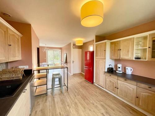 - une cuisine avec des placards en bois et un réfrigérateur rouge dans l'établissement Maison Montauban - 3 chambres - 6 personnes, à Montauban