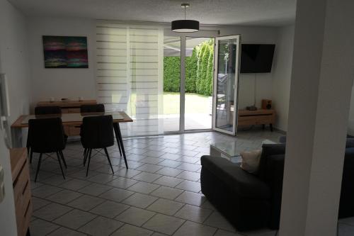 a living room with a couch and a table with chairs at Ferienwohnung mit gemütlicher Terrasse im Nordschwarzwald in Oberreichenbach
