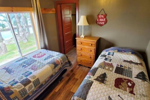 a bedroom with a quilt on a bed and a window at Marina View 1 Bedroom Sunset Cabin in Kabetogama