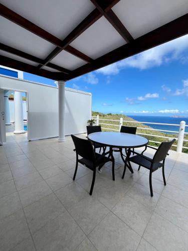 a patio with a table and chairs and the ocean at Sea View Apartments in Kingstown