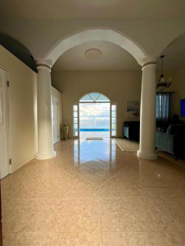 an empty living room with an archway and the ocean at Sea View Apartments in Kingstown