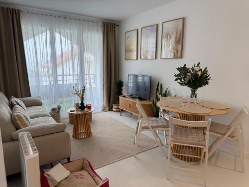 a living room with a table and a couch and a television at Apartamento en Mogro. La Pizca. in Mogro