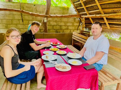 a group of people sitting at a table eating food at Udawalawa Safari House in Udawalawe