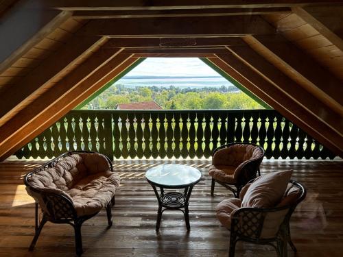a room with chairs and a table on a balcony at Tervey-villa in Révfülöp