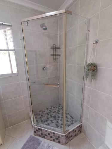 a shower with a glass door in a bathroom at The Loft in Mtunzini