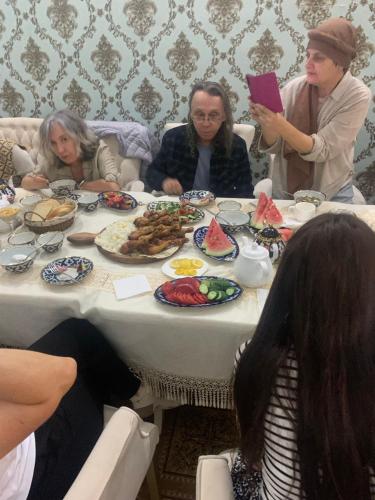 a group of people sitting around a table eating food at UYUT INN Hotel in Samarkand