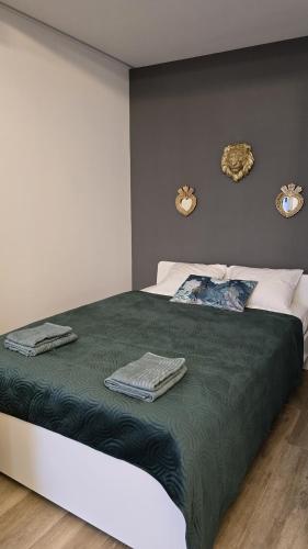 a bedroom with a bed with a green blanket and two mirrors at Inspiracion Valencia in Valencia
