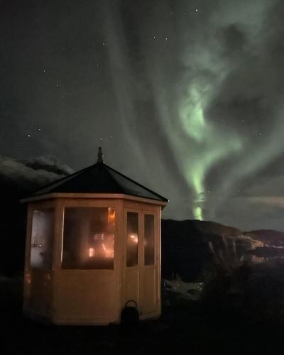 a cabin with a view of the northern lights in the sky at Sigerfjordveien 501 in Sortland