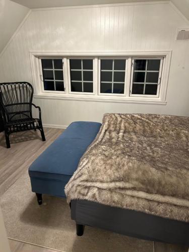 a bedroom with a bed and a chair and a window at Sigerfjordveien 501 in Sortland