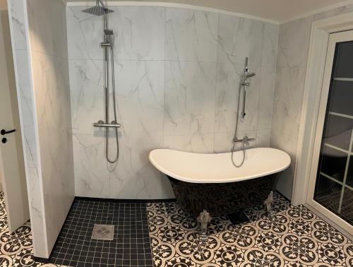 a bathroom with a bath tub and a shower at Sigerfjordveien 501 in Sortland