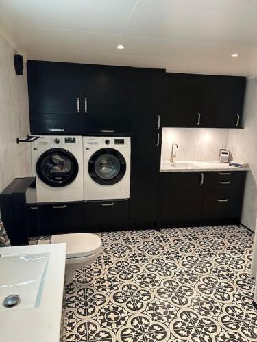 a bathroom with a washer and dryer and a sink at Sigerfjordveien 501 in Sortland
