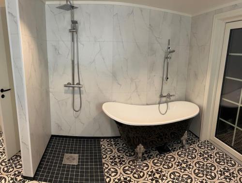 a bathroom with a bath tub and a shower at Sigerfjordveien 501 in Sortland