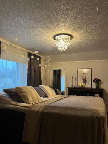 a bedroom with a large bed with a chandelier at Villa Rimppari 3mh 8hlö in Oulu
