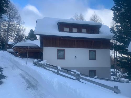 a house covered in snow with a fence at Ferienhaus Vier Jahreszeiten in Reichenau