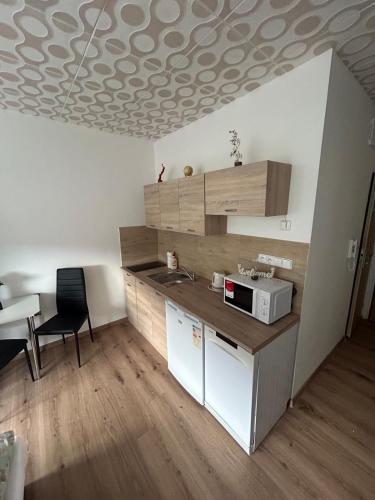 a kitchen with a sink and a microwave on a ceiling at Apartmán ve městě Pernink pro 2 osoby in Pernink