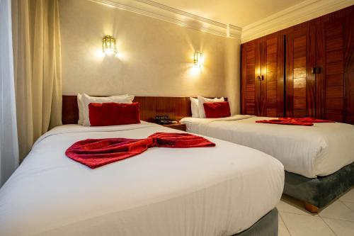 a hotel room with two beds with red pillows on them at Hotel Casablanca City Center in Casablanca
