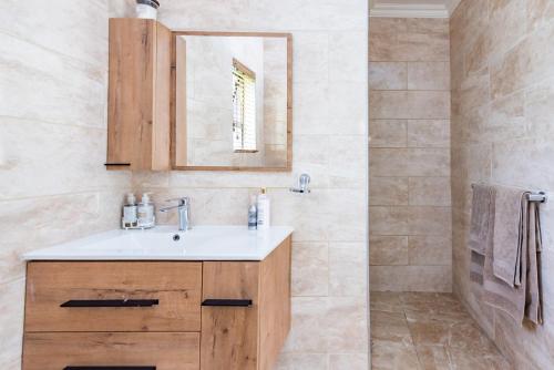 a bathroom with a sink and a mirror at 150 Jacaranda Guesthouse in Midrand