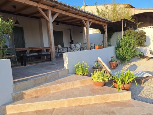 une terrasse avec des escaliers et des plantes en pot dans l'établissement Les Cigales de Saint Quentin la Poterie, à Saint-Quentin-la-Poterie