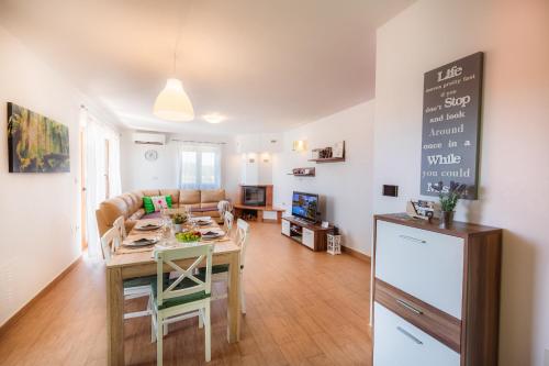 a kitchen and living room with a table and a couch at KIŽIN House, Cozy apartments by Istrian Embrace in Brezovica pri Gradinu