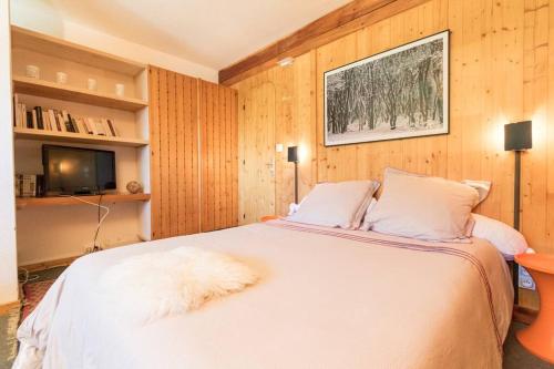 une chambre avec un lit blanc et une télévision dans l'établissement La belle de la Cascade 8 pers - Arcs 1600 station, à Bourg-Saint-Maurice