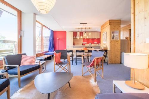 Il comprend un salon avec des chaises et des tables ainsi qu'une cuisine. dans l'établissement La belle de la Cascade 8 pers - Arcs 1600 station, à Bourg-Saint-Maurice