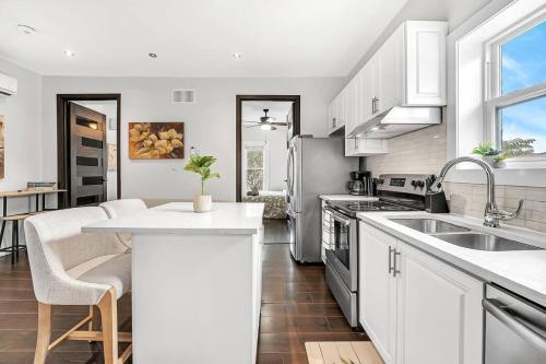 a kitchen with white cabinets and a kitchen island at Luxury 2BR Home Near DT GO Hospitals Waterfalls in Hamilton