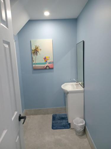 a bathroom with blue walls and a sink and a mirror at Windspire Inn in Port Elgin
