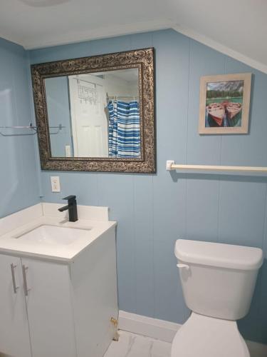 a bathroom with a white toilet and a mirror at Windspire Inn in Port Elgin