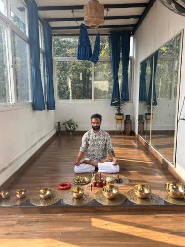 a man sitting on the floor in a room with meditation at Prana Healing House in Pune