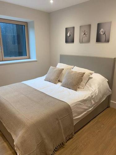 a bedroom with a bed with white sheets and a window at The Barn in Swanmore