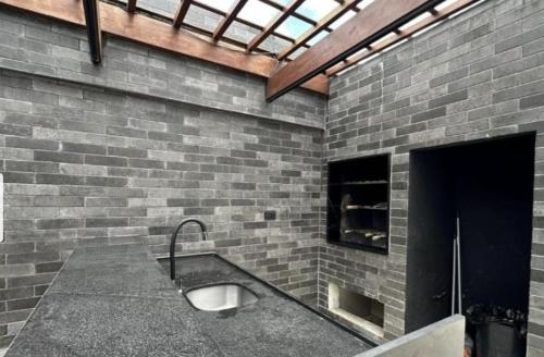 uma casa de banho com uma parede de tijolos e um lavatório. em Beach Class Boa Viagem 4010 em Recife