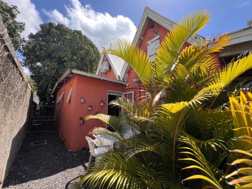 a red house with palm trees in front of it at Ti Lakaz Kreol 2 in Pereybere