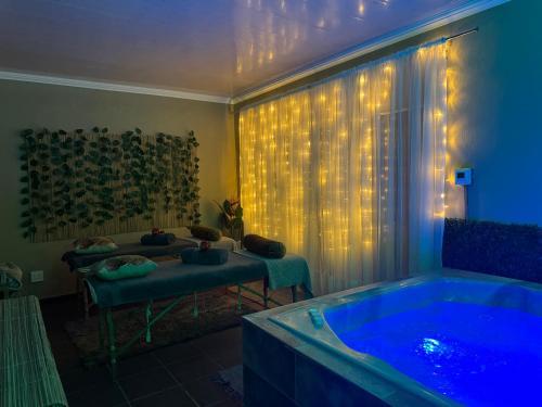a bathroom with a tub and a window with lights at 150 Jacaranda Guesthouse in Midrand