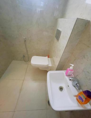 a bathroom with a sink and a toilet at Five BHK Abode in Golf City Lucknow in Nalmatha