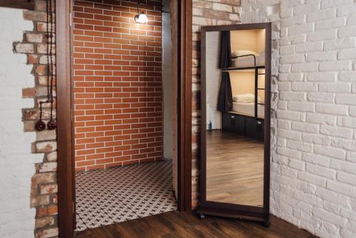 a mirror leaning against a brick wall next to a bedroom at Хостел & Ресторан Сommunity & change the world in Dnipro