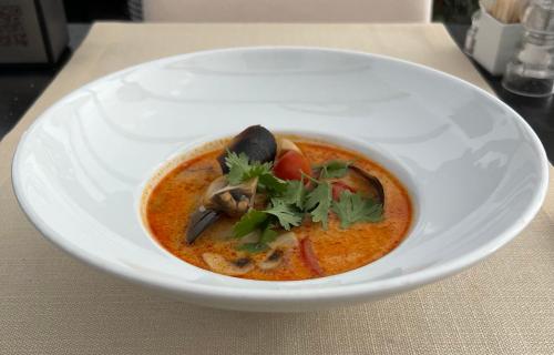 a white plate with a bowl of soup on a table at Хостел & Ресторан Сommunity & change the world in Dnipro