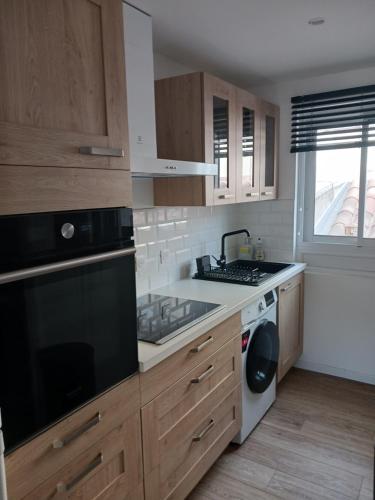 a kitchen with a sink and a stove top oven at Studio de plage in Sète