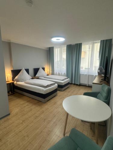 a hotel room with two beds and a table at City Appartement am Hauptbahnhof in Nürnberg