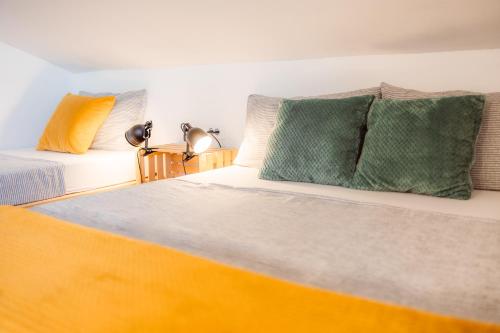 a bedroom with two beds with green and yellow pillows at KIŽIN House, Cozy apartments by Istrian Embrace in Brezovica pri Gradinu