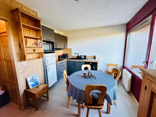 eine Küche mit einem Tisch und Stühlen sowie eine Küche mit einem Tisch und einer Küche in der Unterkunft Studio vue montagne à 200m des pistes in Arâches-la-Frasse