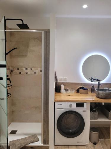 Il comprend une cuisine équipée d'un lave-linge et d'un miroir. dans l'établissement Appartement Au cœur de l'Isle, à LʼIsle-sur-la-Sorgue