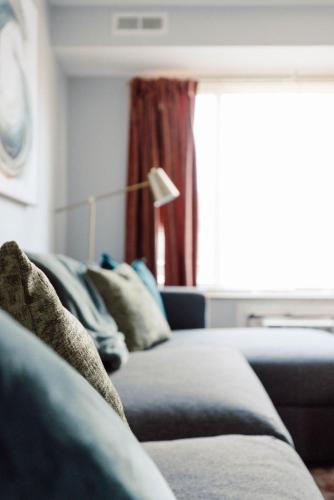 a living room with a blue couch and a window at Heights Dream Libby Unit 6 in Maple Heights