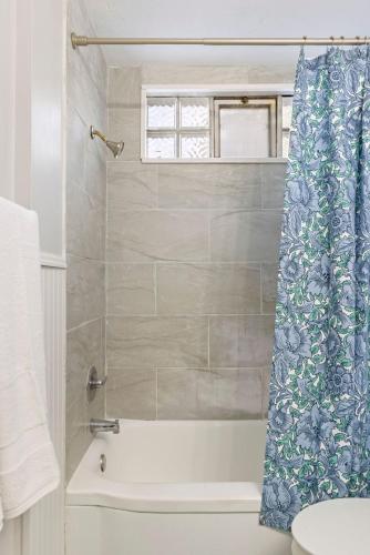 a bathroom with a tub and a shower curtain at Heights Dream Libby Unit 6 in Maple Heights