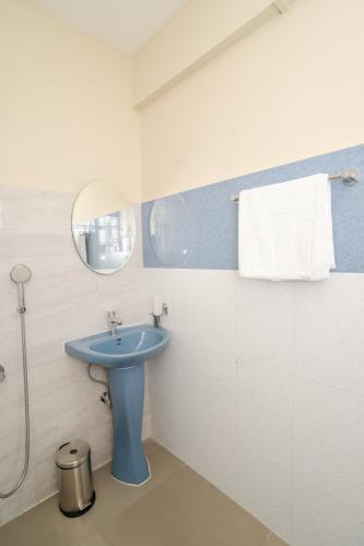 a bathroom with a blue sink and a mirror at Silvermist BnB in Shillong