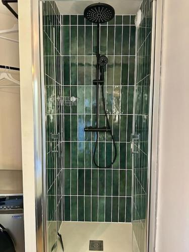 une douche avec une porte vitrée dans une salle de bain dans l'établissement T2 avec parking privatif, à Toulouse